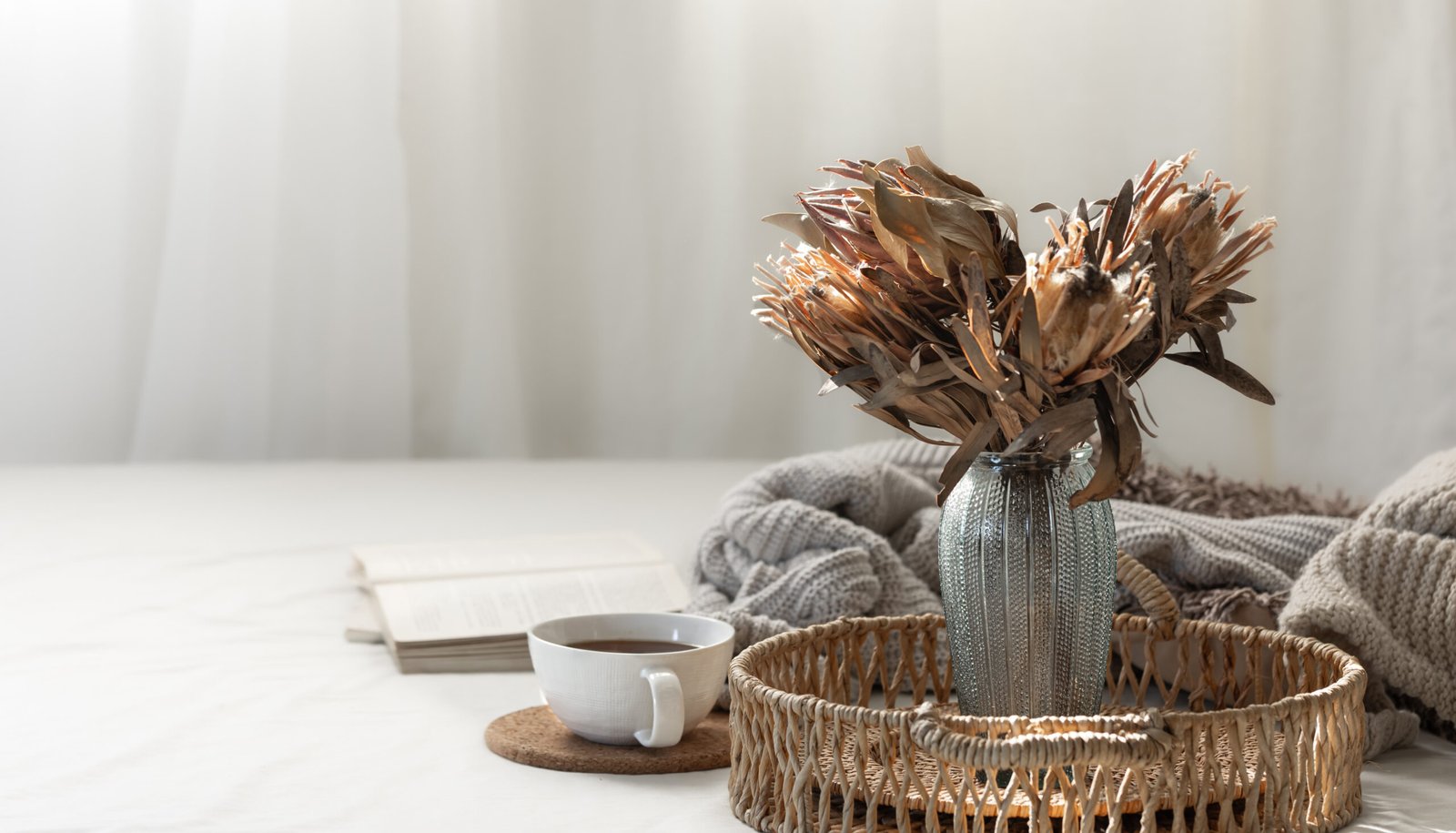 Cup and dried flowers in a vase in the home interior of the living room. Cozy autumn concept. Aesthetic home decoration, boho style. Copy space.